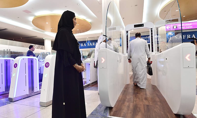 A Passengers walks through a "smart tunnel " at Dubai airport T3 in United Arab Emirates on October 10, 2018. - The Smart tunnel using face recognise tecnology, will check the passengers passport as they walk through it. (Photo by GIUSEPPE CACACE / AFP)
